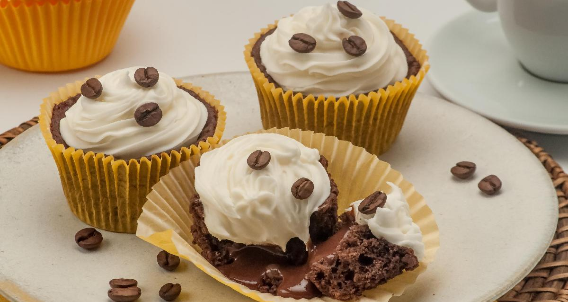 Imagem de um copcake com chantilly e grãos de café